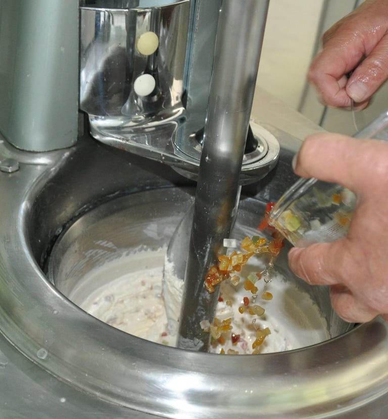 Nos artisans glacier mélangeant les fruits confits d'Apt et le Kirsch avec la crème glacé