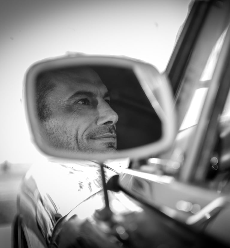 a man in a car mirror and a car mirror