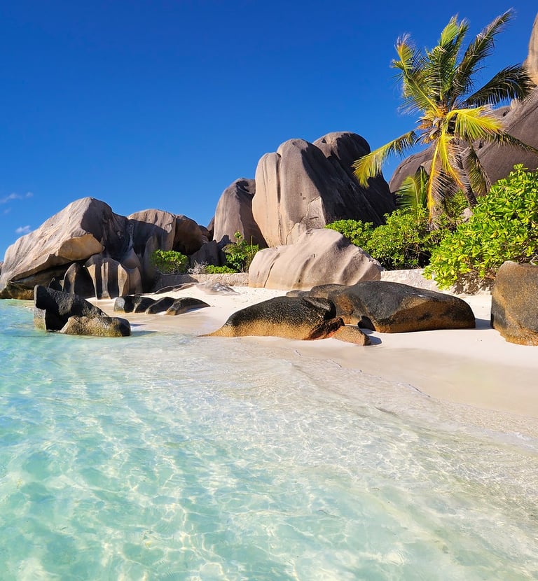 Idyllic Seychelles beach with granite boulders, white sand, and turquoise water.