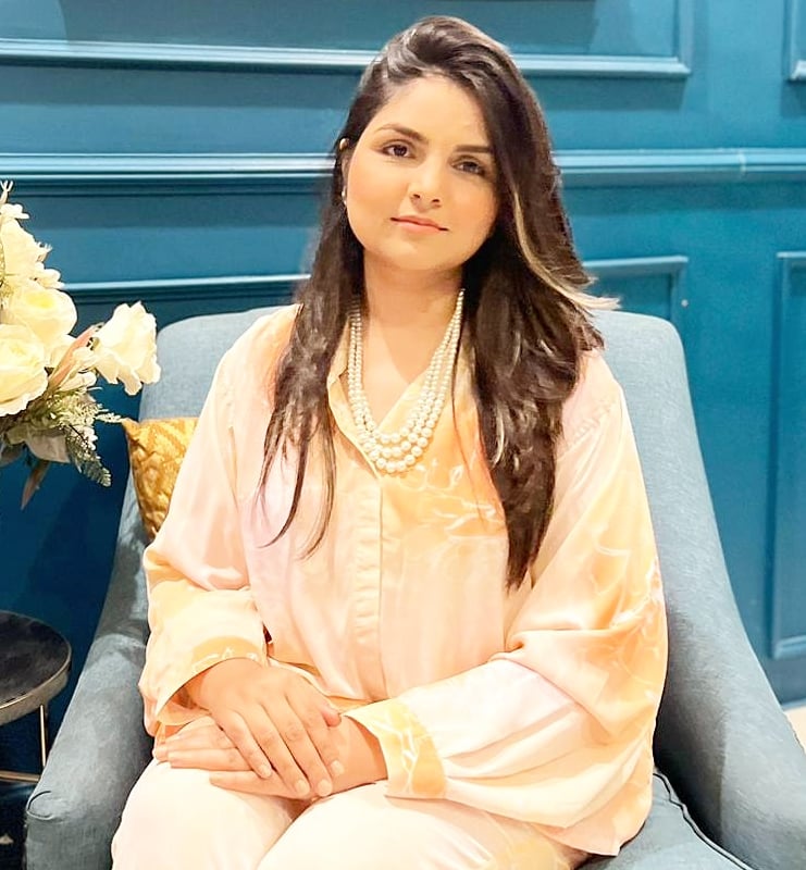 a woman sitting in a chair with a vase of flowers