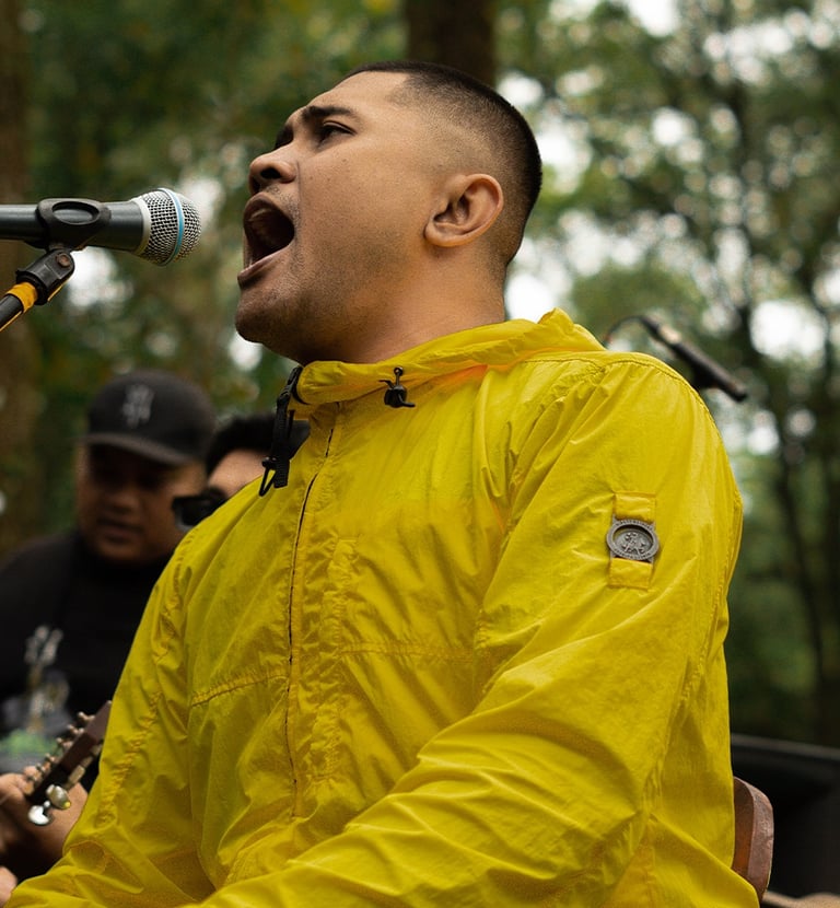 a man in a yellow jacket singing into a microphone