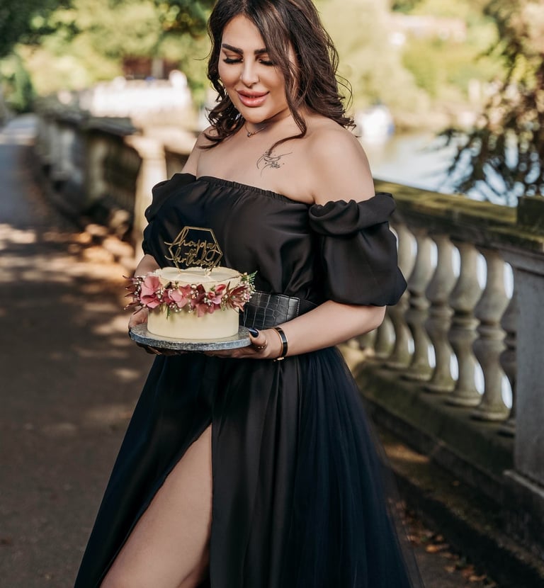 Outdoor portrait of woman in black dress holding cake – Fred Art Studio London