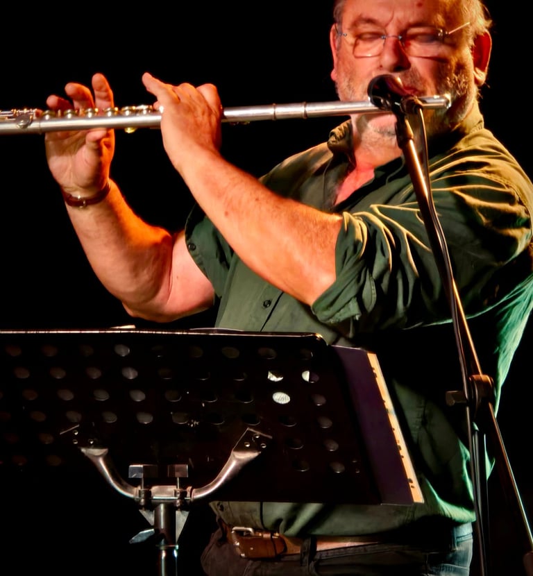 MArcel Tabone joue de la flûte traversière sur scène avec un fond noir