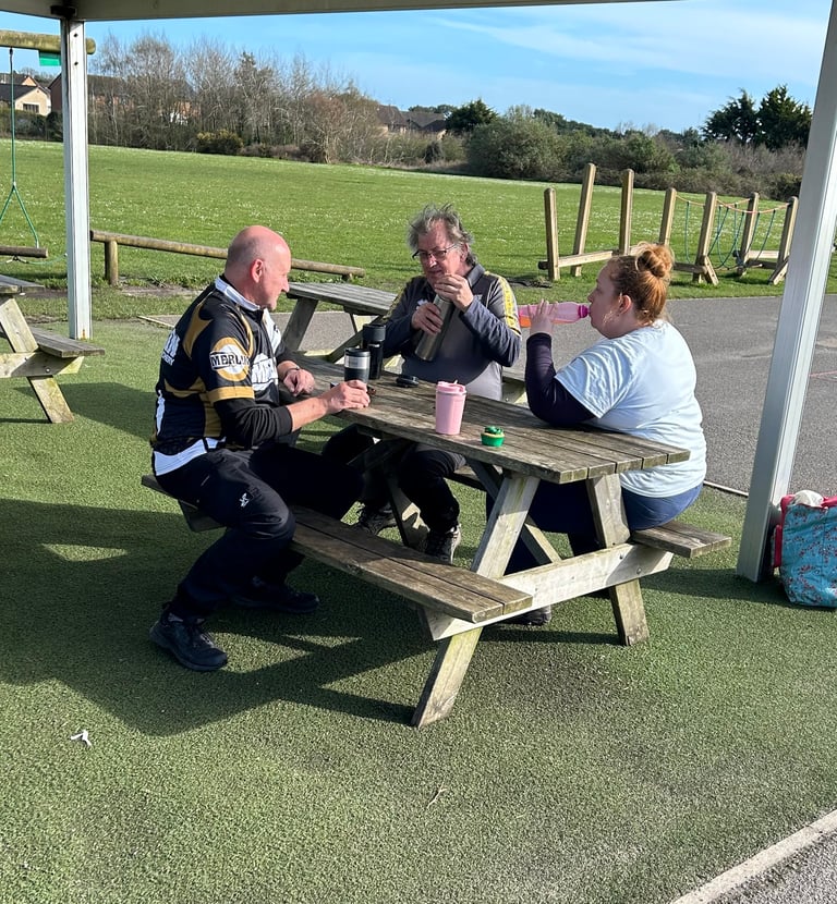 a group of archers having lunch at a picnic table