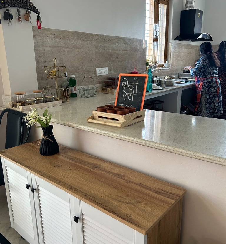 A modern white and wood sideboard in a clean kitchen with a chalkboard menu on the counter.