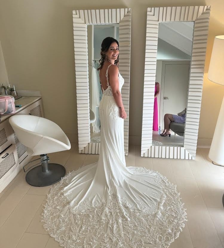 a woman in a wedding dress standing in front of a mirror
