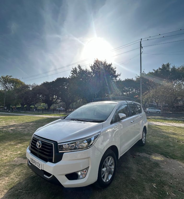 a white toyota fortuner parked in a field