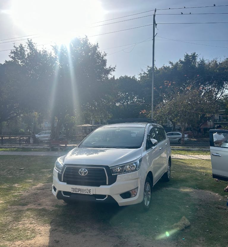 a white toyota fortuner parked in a grassy area