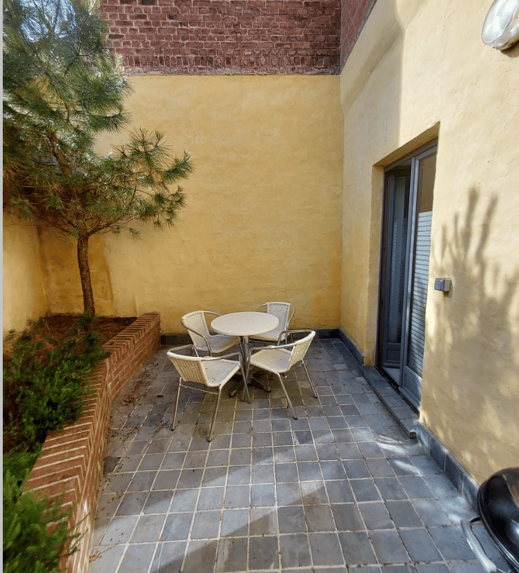 Cour intérieure avec mobilier et végétation accessible depuis un bureau