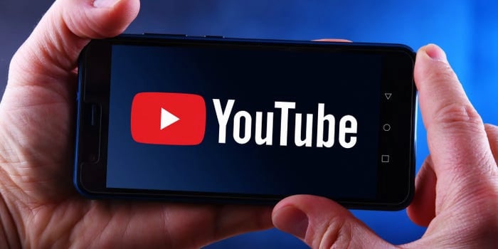a person holding a phone with the youtube youtube logo on it