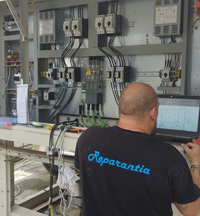 Técnico programando controlador de sistemas de central frigorífica.