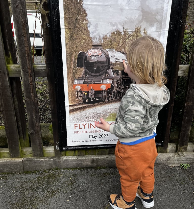 toddler looking at Flying Scotsman poster