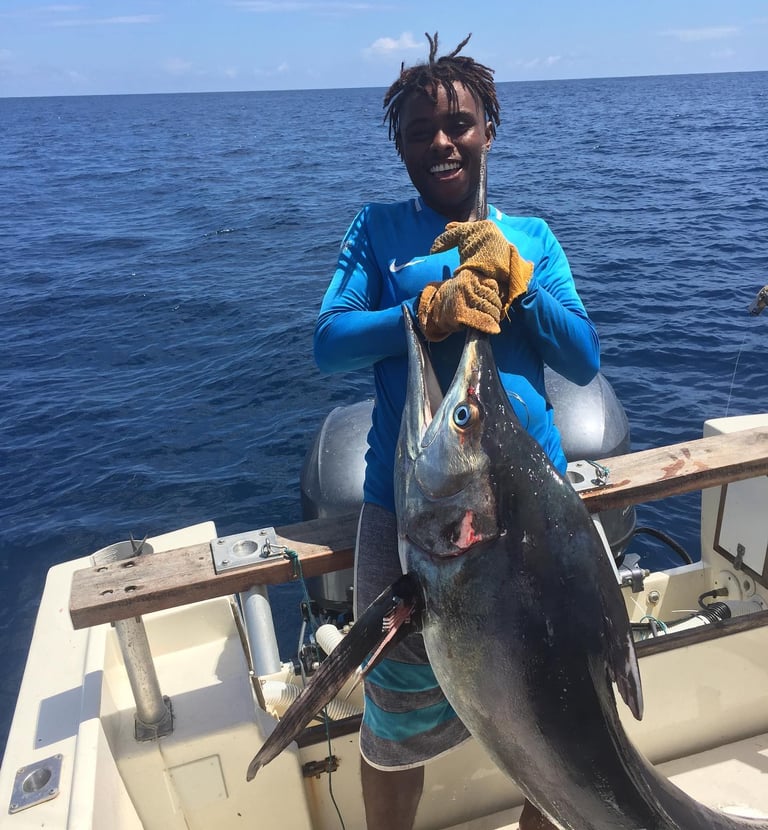 a man holding a fish on a boat