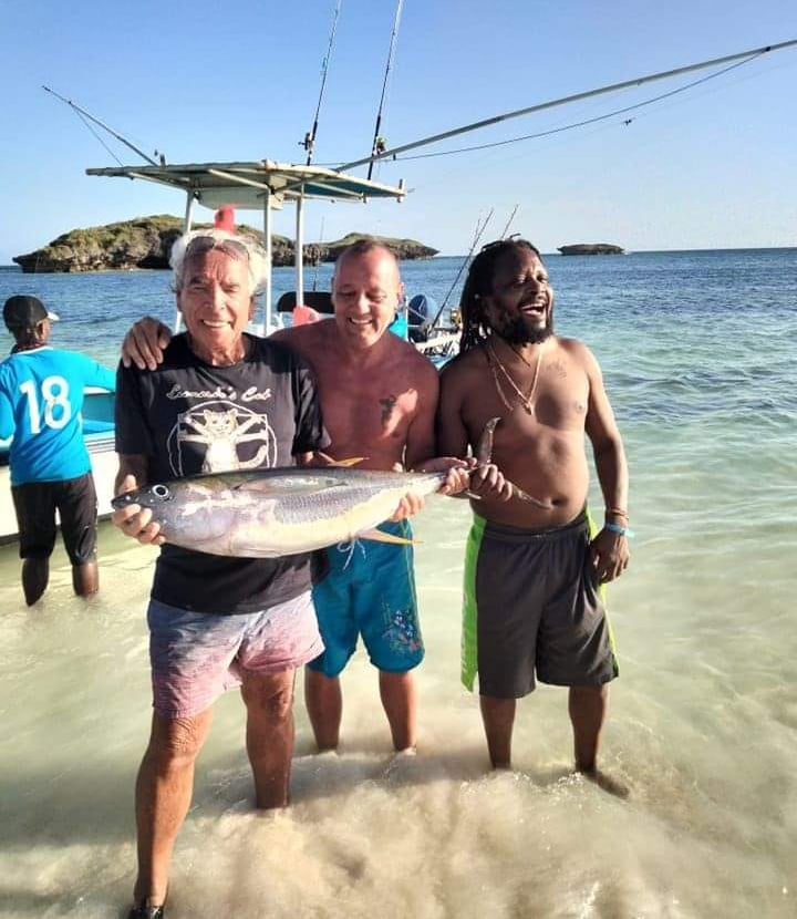 a man holding a fish on a boat