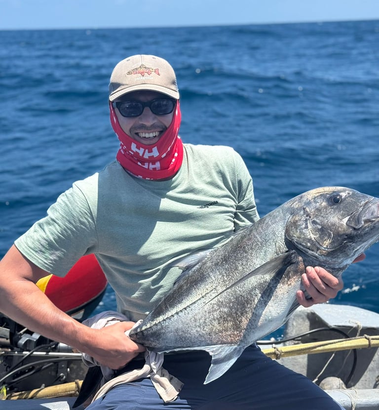 a man in a bandannard is holding a fish