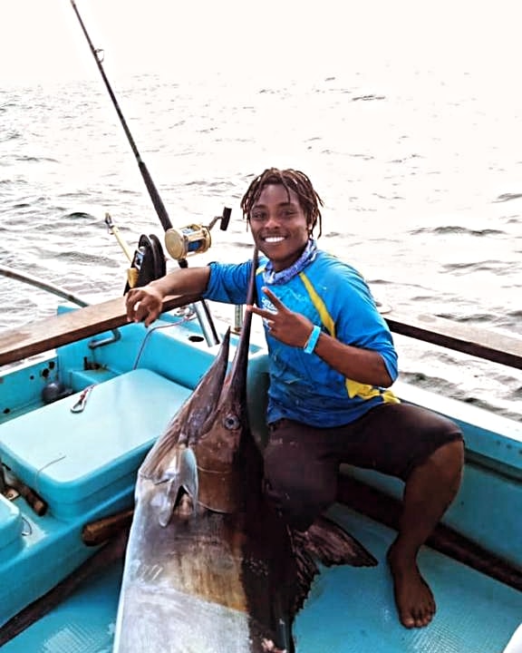 a man holding a fish on a boat