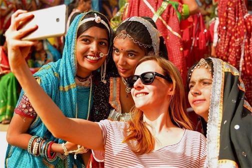 a group of women in colorful saris taking a selfie