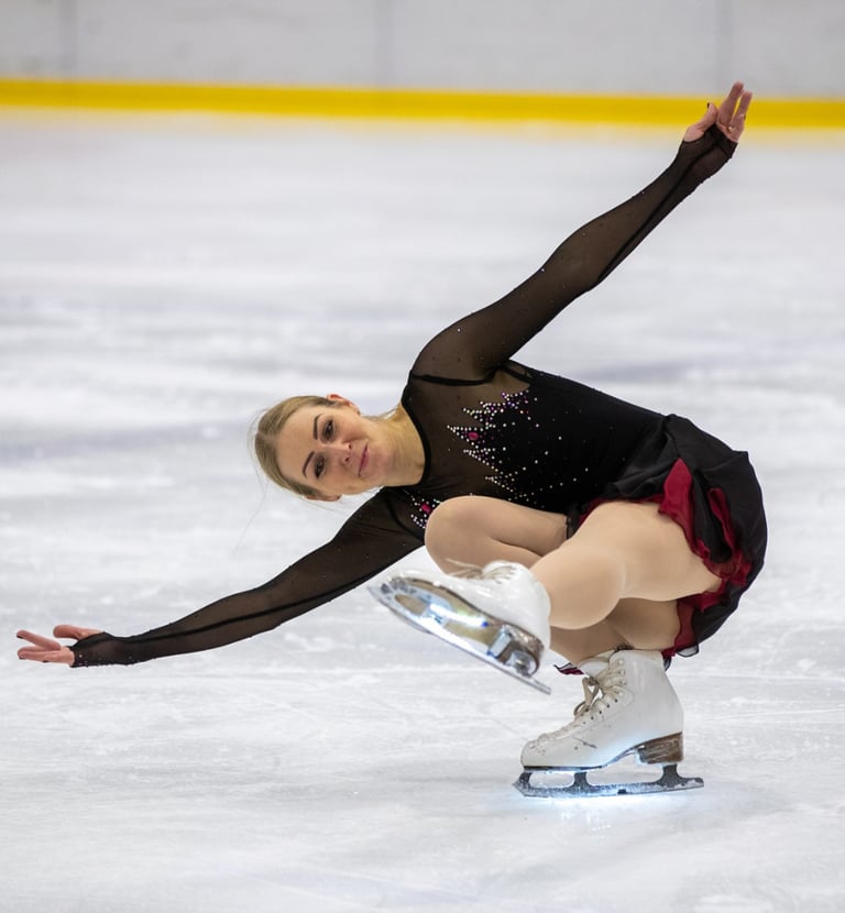 Adult figure skater performing element