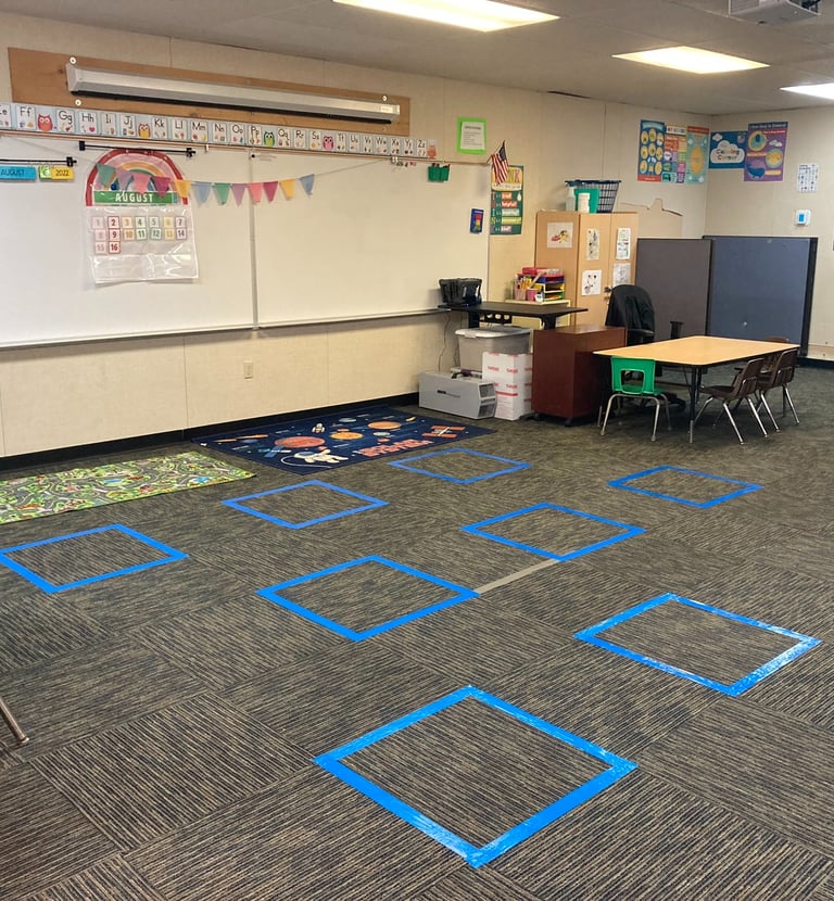 a classroom room with a whiteboard and blue tape tape