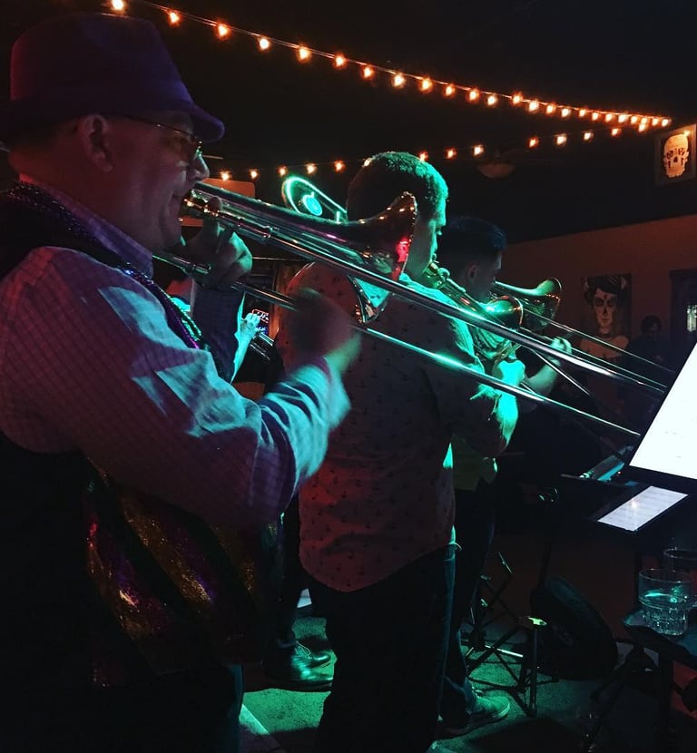 a man playing trombone in river city riot brass band, mardi gras, new orleans music