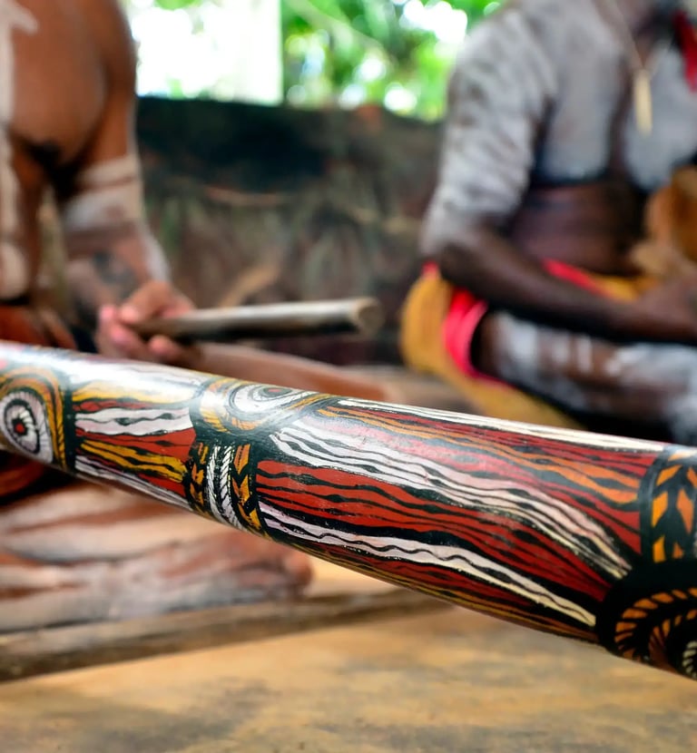 two men one player a didgeridoo the other playing clapsticks