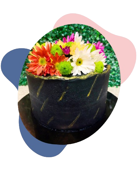 Bolo elegante de buttercream preto coberto com margaridas coloridas frescas e detalhes em glitter