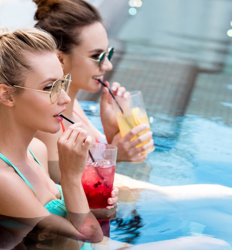 Two women sipping cocktails in the pool during a Vegas Pool Party Crawl