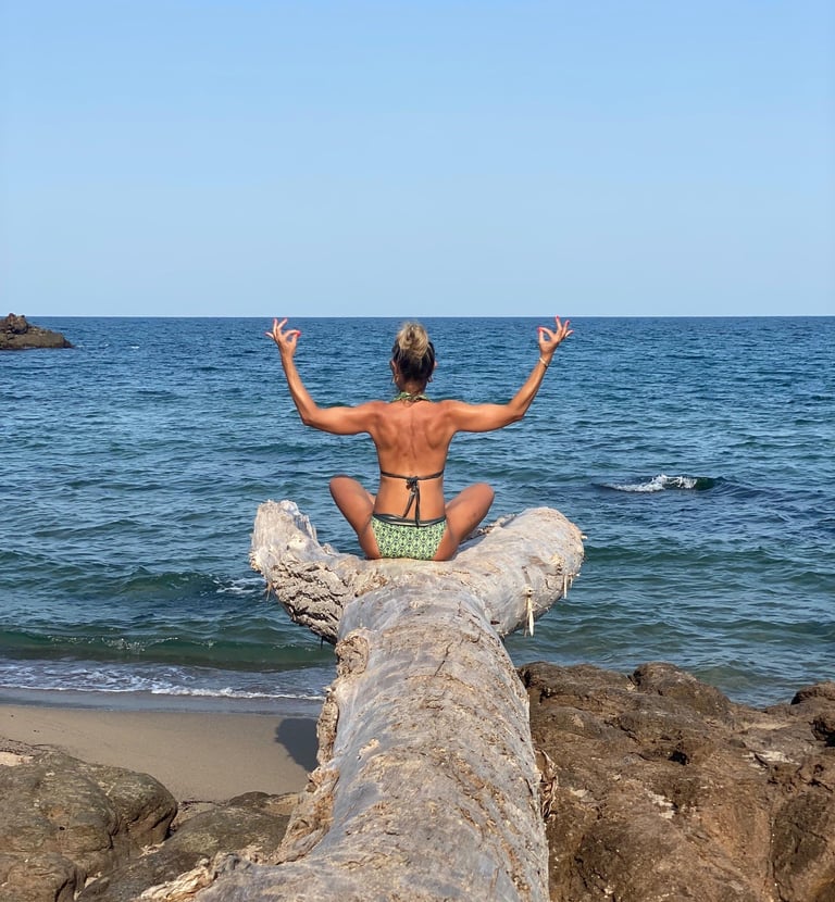 Yoga teacher practicing on a wild beach near Lozenets: A serene, nature-led setting for Yogessa retreats.