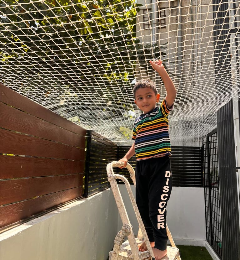 Technician installing a pigeon net on a residential balcony in bright daylight.