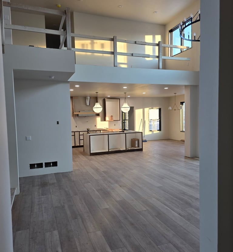 Modern open concept kitchen and living area with luxury vinyl plank flooring and mezzanine balcony.
