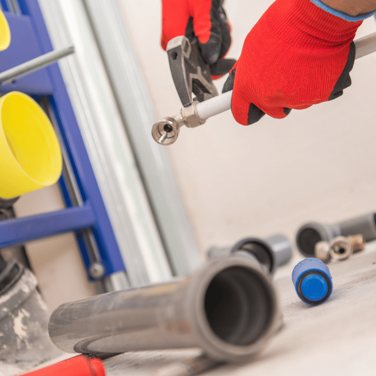 Sanitärinstallateur montiert Rohrleitungen und Anschlüsse im Badezimmer