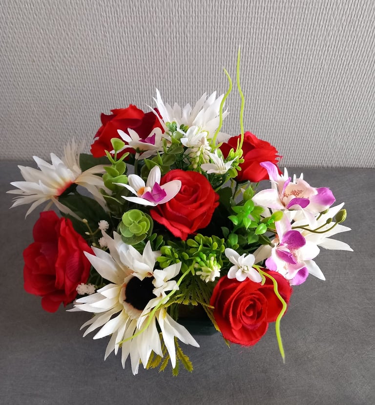 Arrangement de fleurs artificielles avec des roses rouges et des marguerites blanches dans un vase p