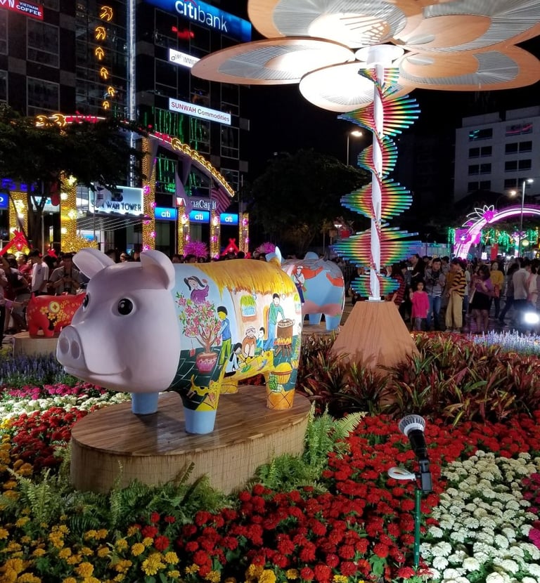 Festive pig statue with floral art at a vibrant night market display for Lunar New Year celebrations.