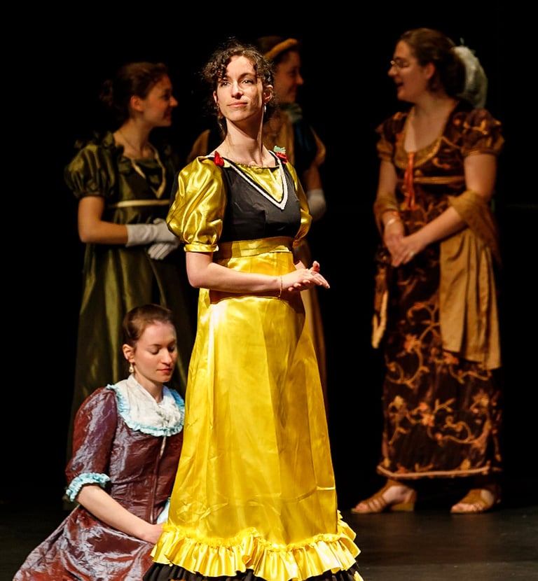 Aude Fy, en costume d'époque jaune dans une pièce de théâtre, interprétant une cantatrice