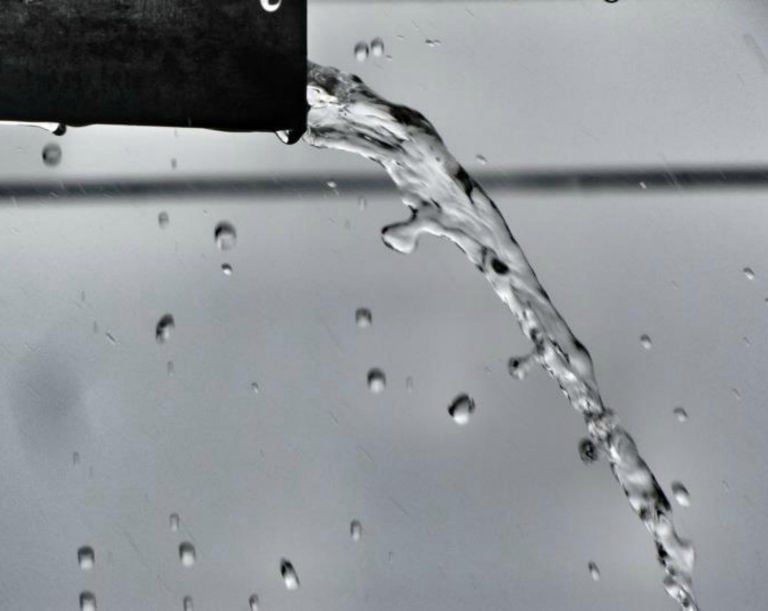 a black and white photo of a water fountain