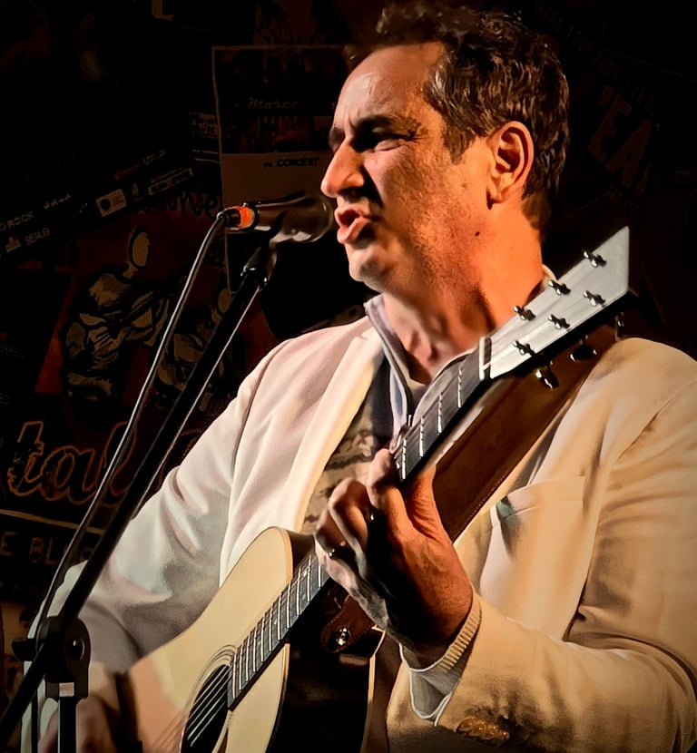 Joël Royer chantant sur scène en trois quart avec sa Martin guitare electro-acoustique