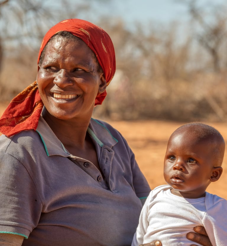 a woman in a red shirt and a baby in a red hat