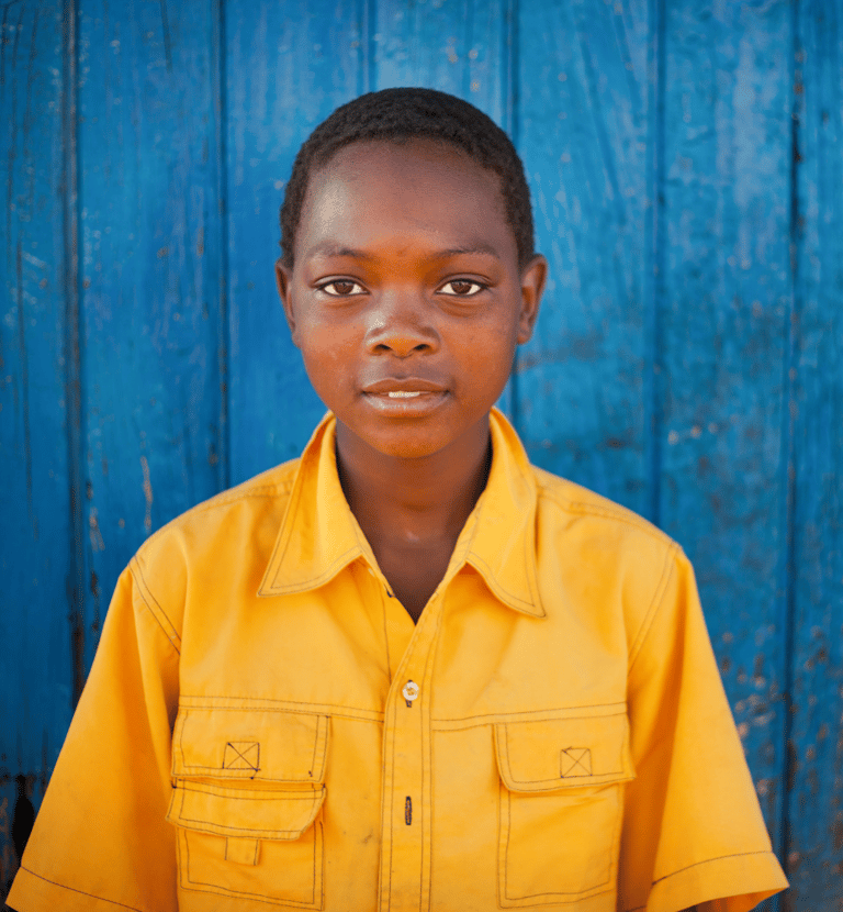 a young boy in a yellow shirt and a blue background