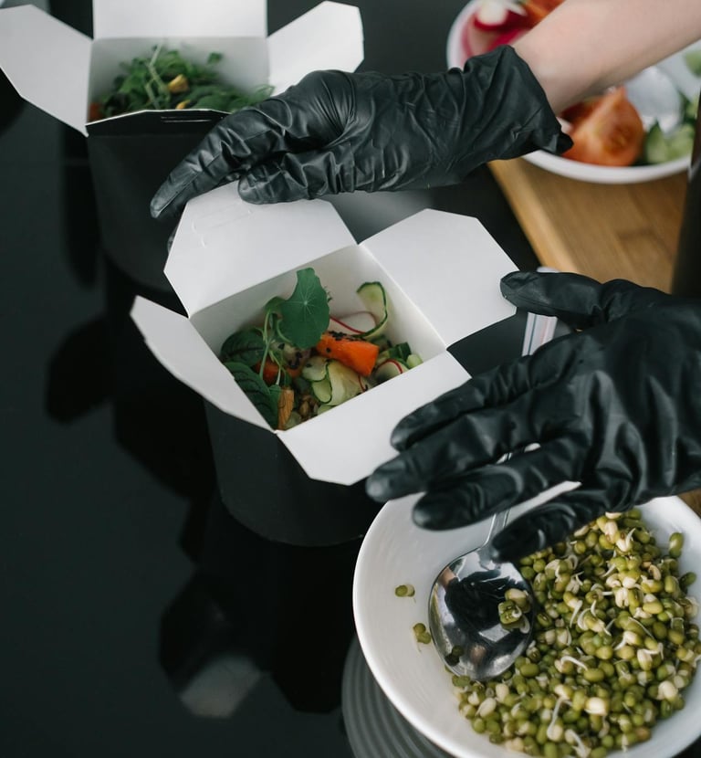 Bientôt disponible  Une personne portant des gants tenant une boîte de nourriture
