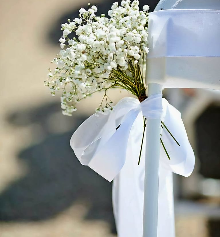 Silla para boda decorada con un liston blanco y flores