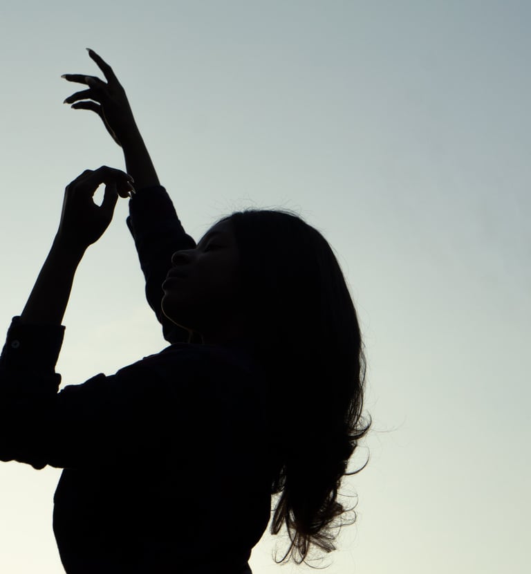 Photograph of a lady elegantly placing her arms up in the sky