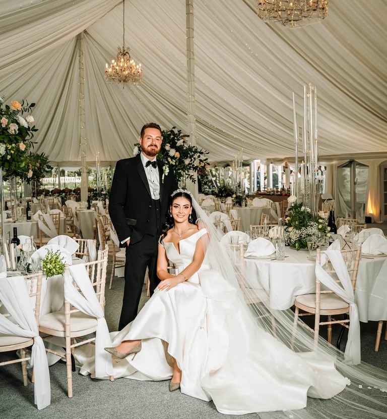 Bride and groom in an elegant white wedding marquee