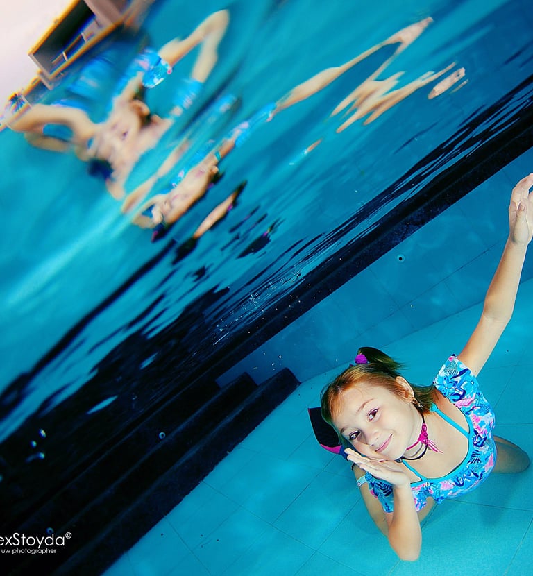 a girl in a swimsuit is swimming in a pool underwater