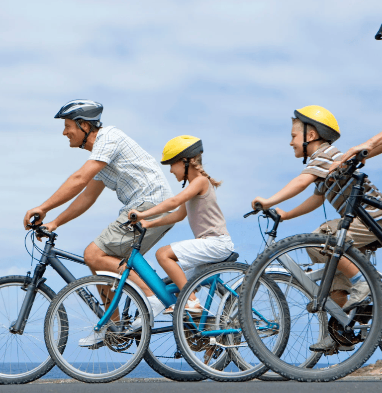 A family of three cycling in the outdoors.