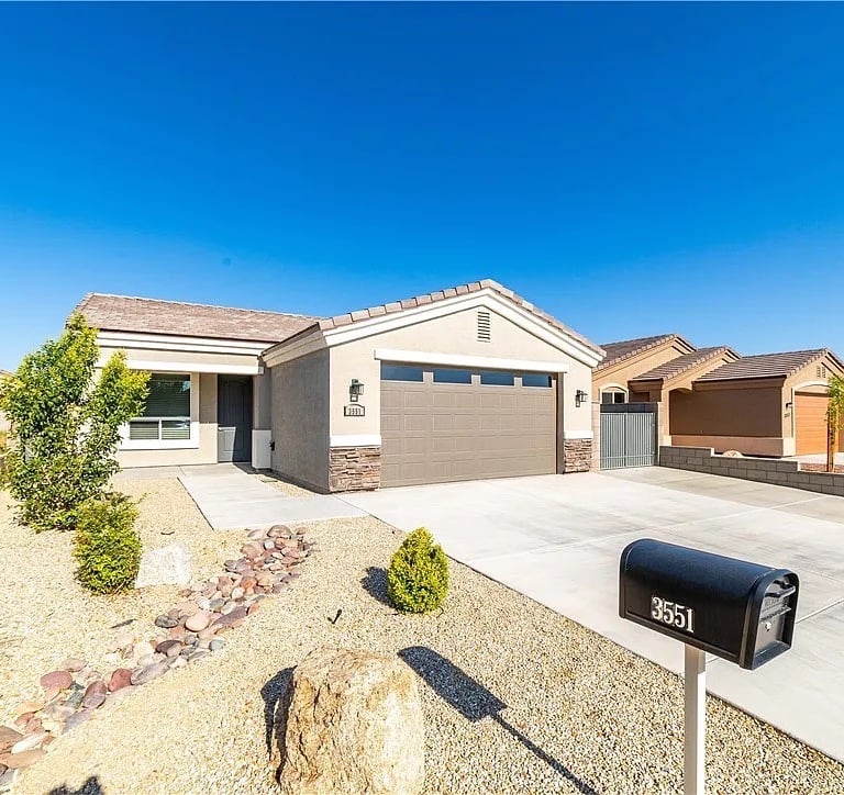 The front exterior with a garage and driveway of a custom home