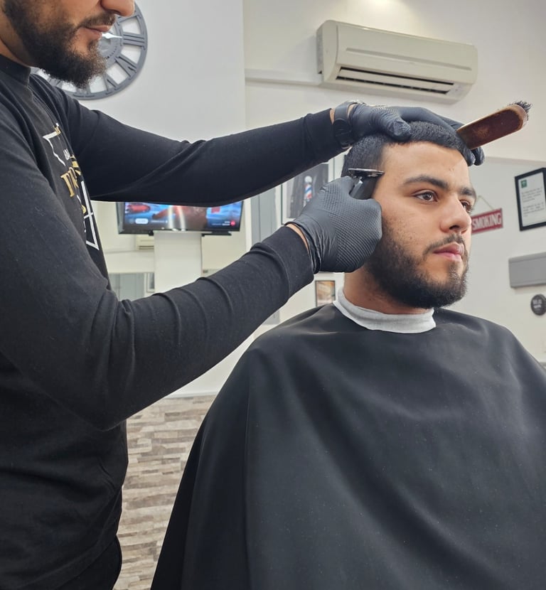 Peluquero dando su corte de pelo al cliente.
