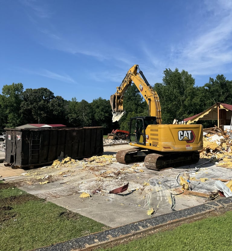 Excavator loading materials on a residential demolition site