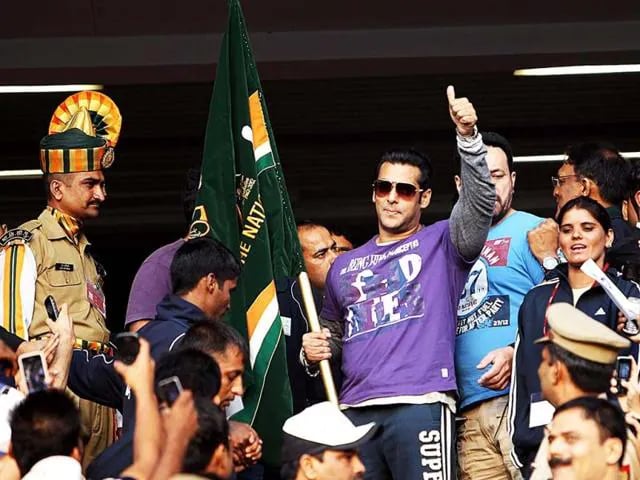 a man in a purple shirt and a man in a hat and sunglasses
