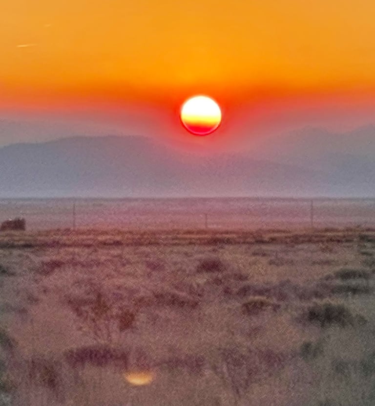 a sunset with a red sun setting in the background