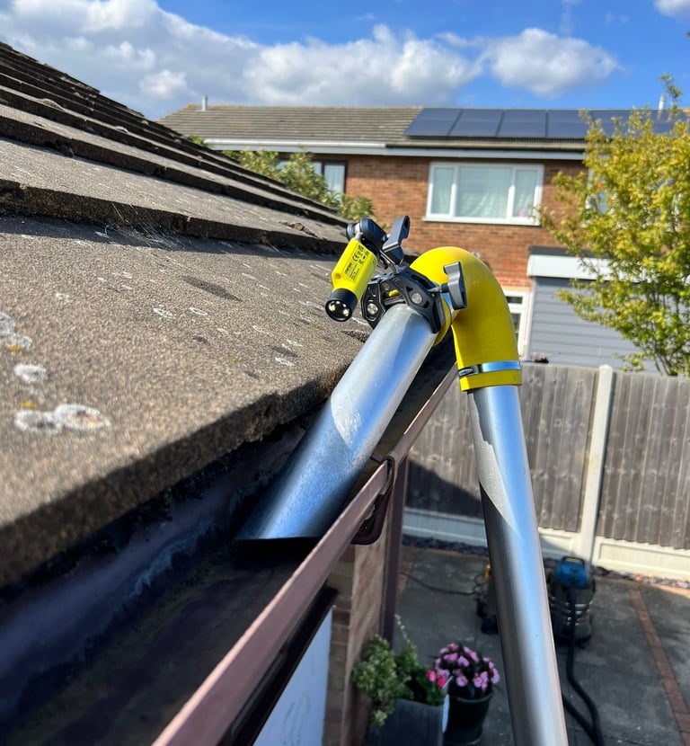 Vac gutter cleaning of a bungalow roof with an inspection camera attached